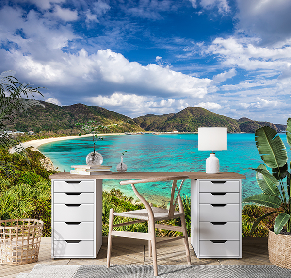 Tokashiki Island in Okinawa, Japan, featuring pristine sands, turquoise waters teeming with vibrant coral reefs, and lush green hills under a cerulean sky.